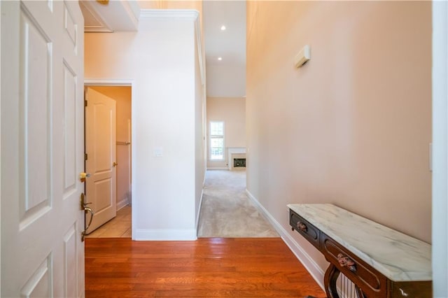 hall featuring baseboards, light wood finished floors, and recessed lighting