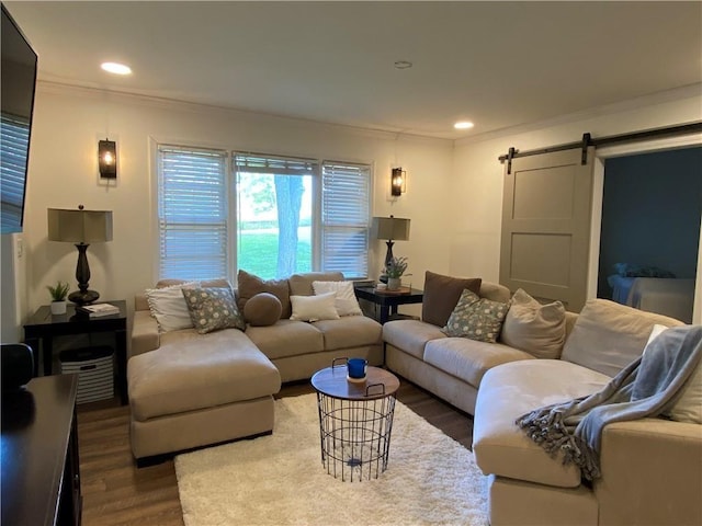 living room featuring hardwood / wood-style flooring, a barn door, and ornamental molding