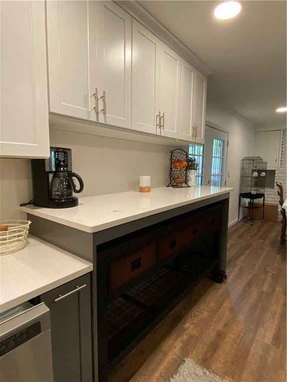 kitchen with stainless steel dishwasher, white cabinetry, and dark wood-type flooring