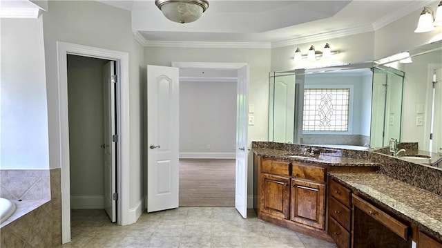 full bathroom featuring tile patterned floors, crown molding, baseboards, a bath, and vanity