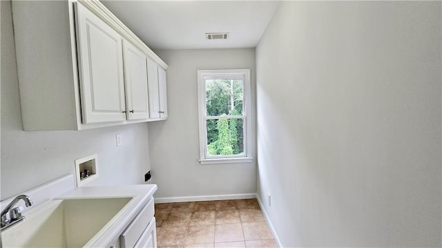 clothes washing area with visible vents, baseboards, washer hookup, cabinet space, and a sink