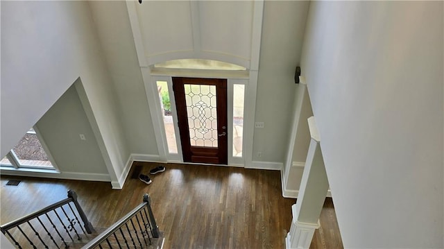 foyer with visible vents, baseboards, lofted ceiling, and wood finished floors