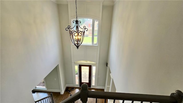 entrance foyer featuring baseboards, a notable chandelier, a high ceiling, and wood finished floors