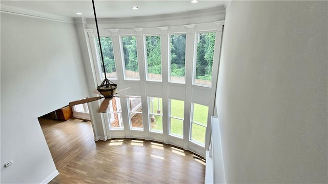 unfurnished living room with ceiling fan, recessed lighting, wood finished floors, and crown molding