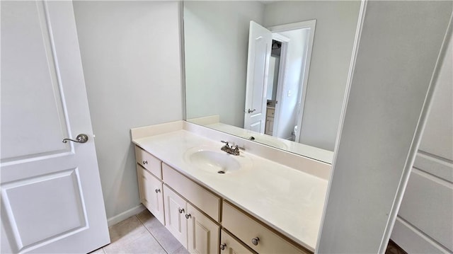 bathroom with baseboards, toilet, vanity, and tile patterned flooring