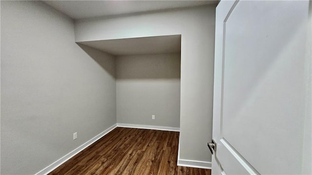 spare room featuring dark wood finished floors and baseboards