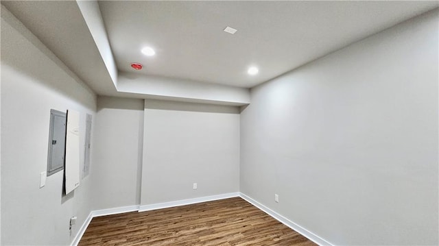 empty room featuring recessed lighting, baseboards, electric panel, and dark wood finished floors