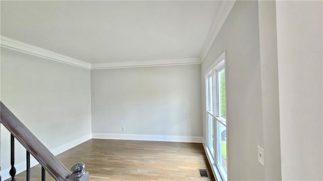 unfurnished room featuring crown molding, baseboards, and wood finished floors