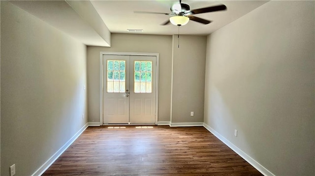 doorway featuring dark wood-style floors, a ceiling fan, visible vents, baseboards, and french doors