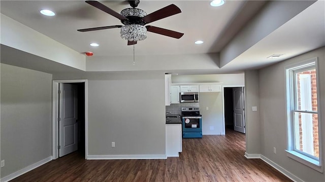 interior space featuring dark wood-type flooring, tasteful backsplash, white cabinetry, stainless steel appliances, and baseboards