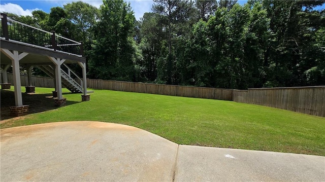 view of yard featuring stairway, a wooden deck, a fenced backyard, and a patio area