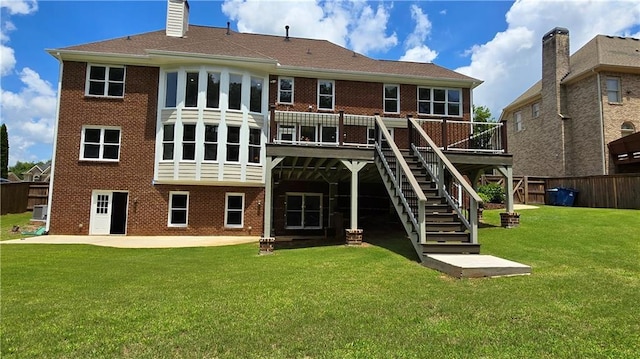 back of house featuring a patio, stairway, a yard, a deck, and brick siding