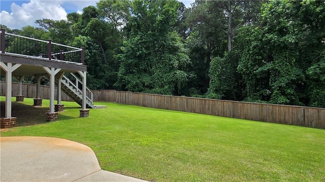 view of yard with stairs, a fenced backyard, and a wooden deck