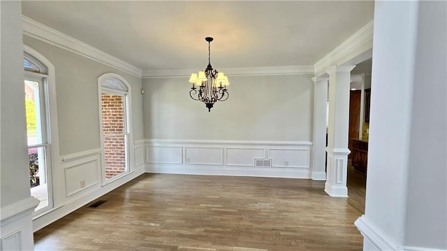 unfurnished dining area with a notable chandelier, wood finished floors, visible vents, and ornamental molding