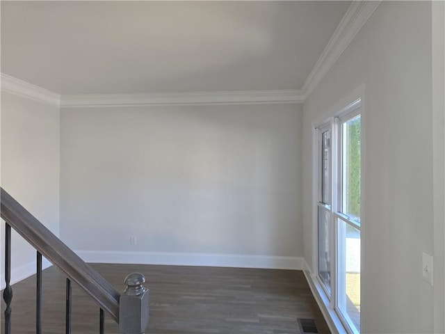 unfurnished room with visible vents, baseboards, dark wood-style floors, and ornamental molding