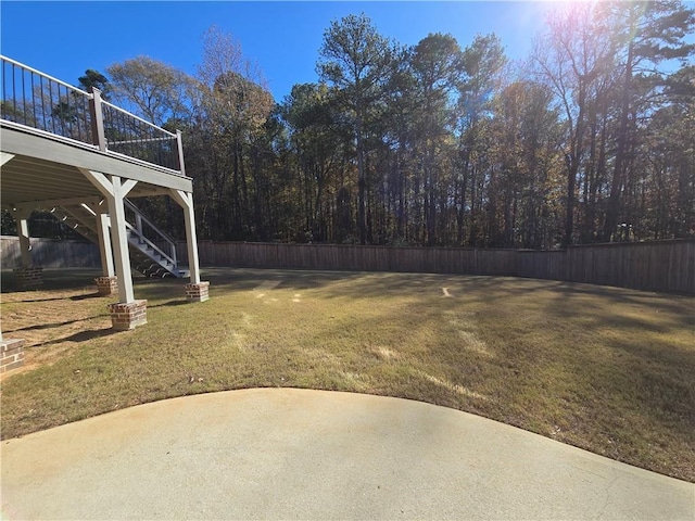 view of yard with stairway, a wooden deck, a patio, and fence