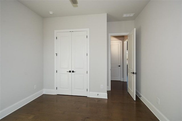 unfurnished bedroom featuring dark hardwood / wood-style floors, a closet, and ceiling fan