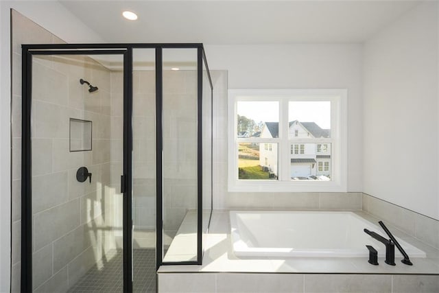 bathroom featuring independent shower and bath