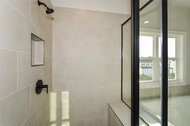 bathroom featuring a tile shower and a wealth of natural light