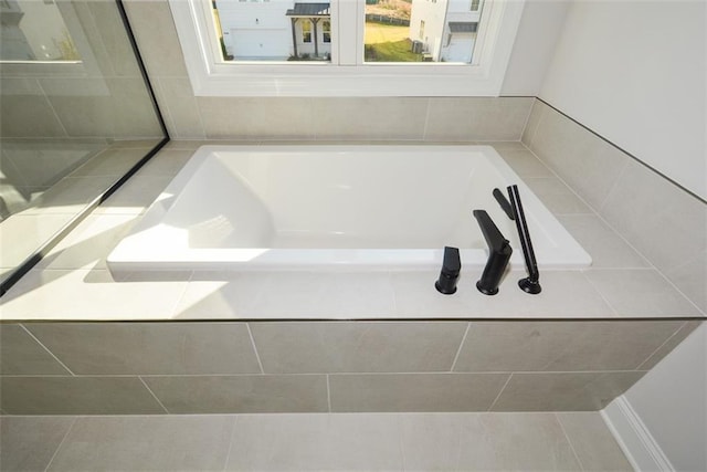 bathroom with a relaxing tiled tub