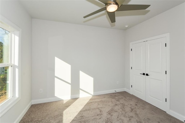 unfurnished bedroom featuring a closet, light colored carpet, and ceiling fan