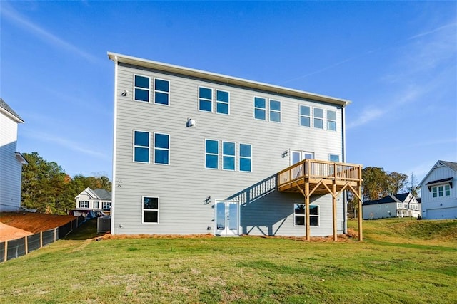 rear view of house with a lawn, central AC unit, and a deck