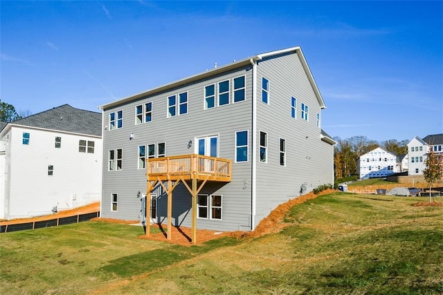 rear view of property featuring a lawn and a deck