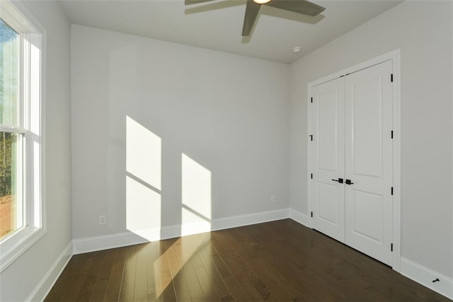 unfurnished room featuring dark hardwood / wood-style floors, a wealth of natural light, and ceiling fan