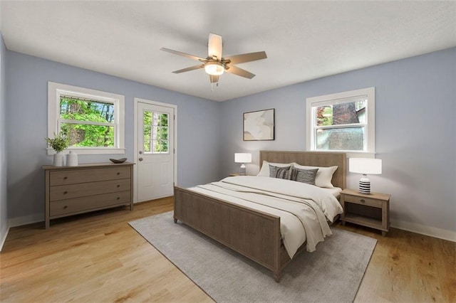 bedroom with baseboards, ceiling fan, and light wood-style floors