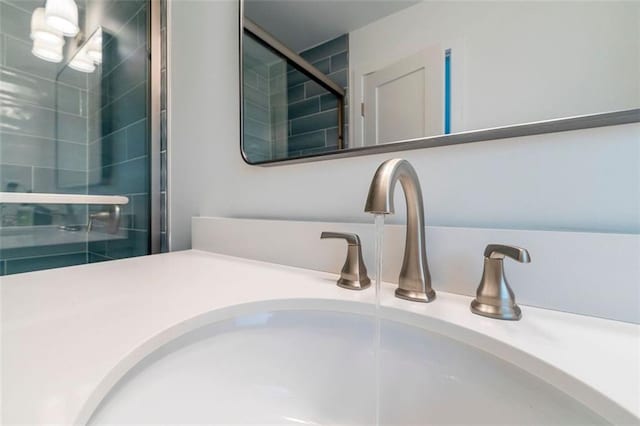 details with vanity and a tile shower