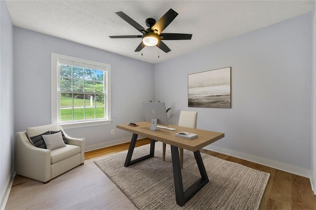 office area featuring baseboards, a ceiling fan, and wood finished floors