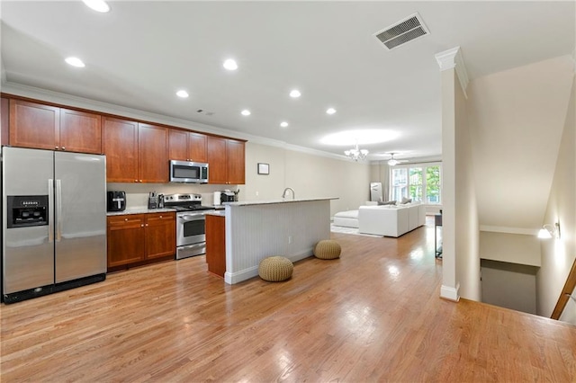 3642 Princeton Ave, Atlanta, GA 30337 - kitchen with appliances with stainless steel finishes, ornamental molding, open floor plan, light wood-style floors, and light countertops
