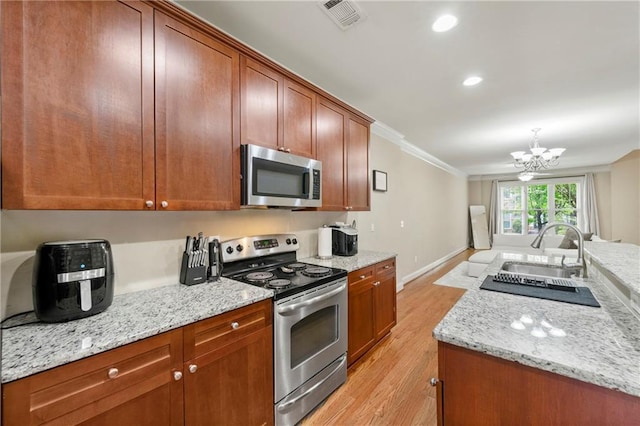3642 Princeton Ave, Atlanta, GA 30337 - kitchen with appliances with stainless steel finishes, light wood-type flooring, a chandelier, ornamental molding, and light stone countertops