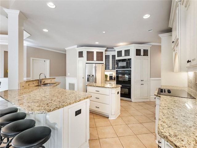 kitchen featuring black appliances, white cabinetry, sink, kitchen peninsula, and light stone countertops