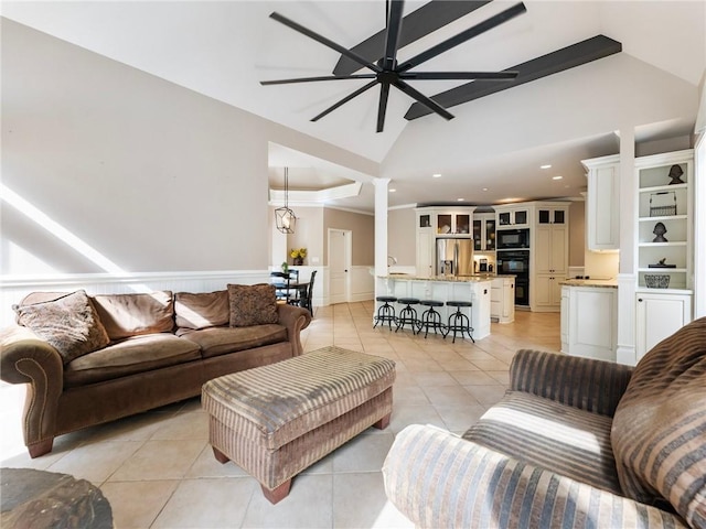 living room featuring light tile patterned flooring, ceiling fan, lofted ceiling, and decorative columns