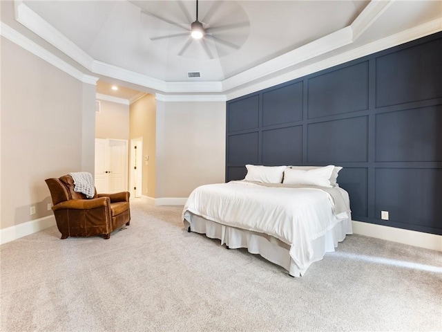 carpeted bedroom featuring crown molding, ceiling fan, and a tray ceiling