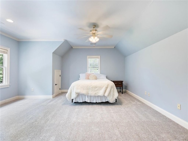 carpeted bedroom with crown molding, lofted ceiling, and ceiling fan