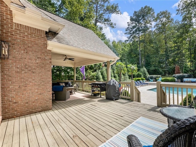 wooden terrace featuring a fenced in pool and ceiling fan