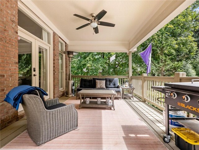 deck with outdoor lounge area, ceiling fan, and french doors