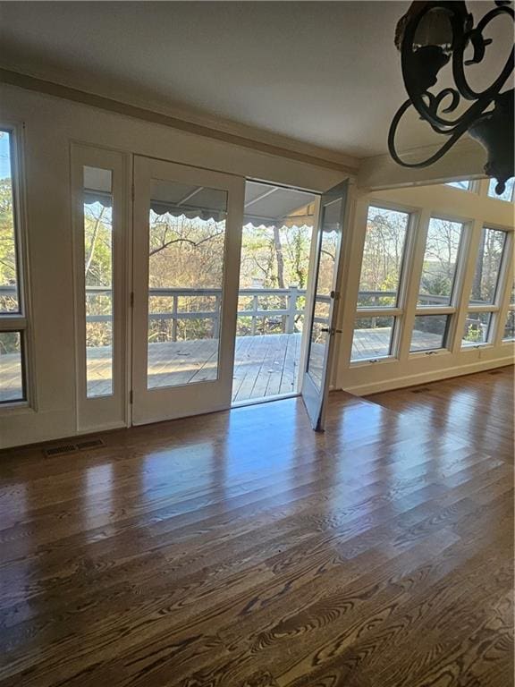 doorway with dark hardwood / wood-style floors, ornamental molding, and french doors