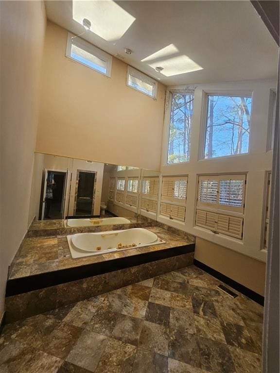 bathroom featuring a wealth of natural light and a high ceiling