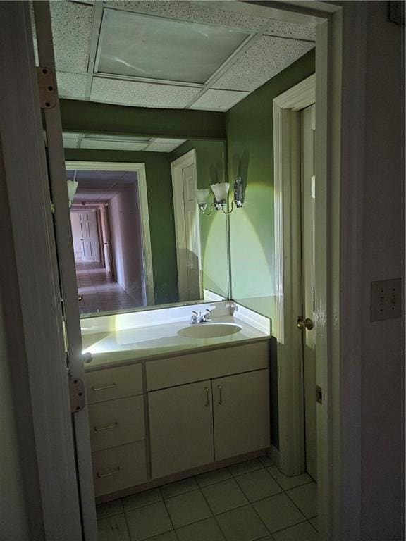 bathroom featuring a drop ceiling, vanity, and tile patterned flooring