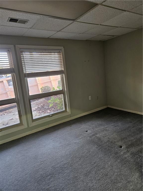 empty room with a paneled ceiling and carpet