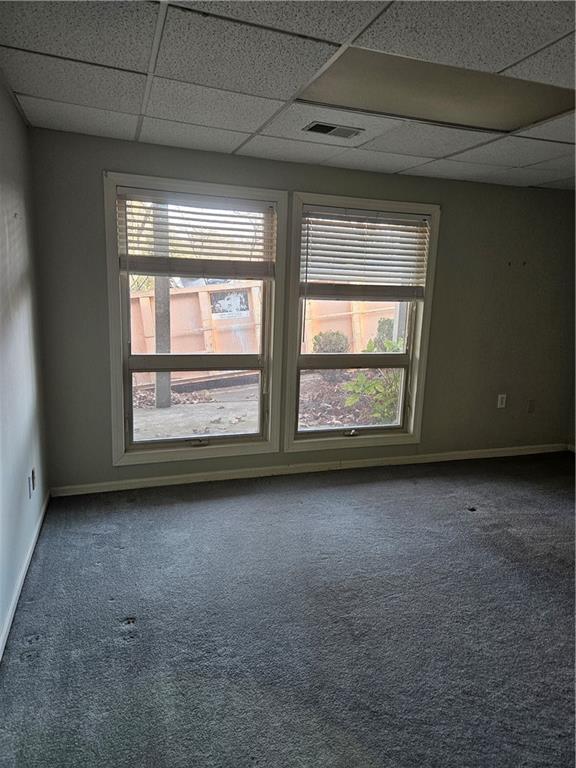 spare room with carpet floors and a paneled ceiling