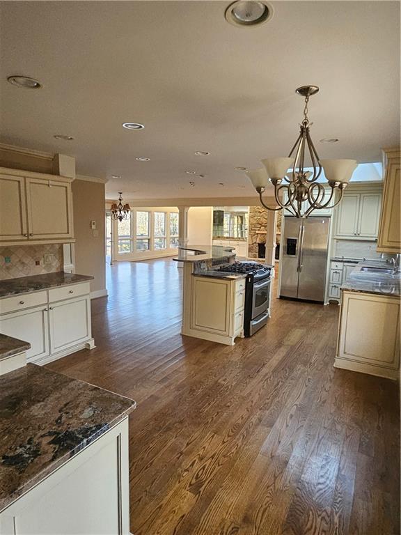 kitchen featuring appliances with stainless steel finishes, tasteful backsplash, sink, pendant lighting, and cream cabinets