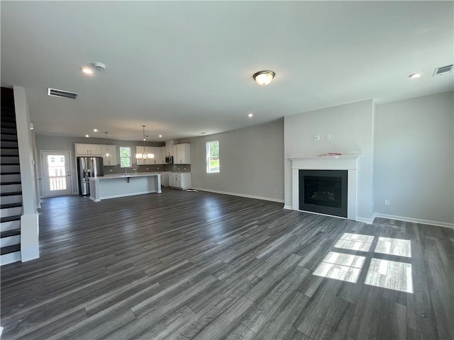 unfurnished living room with dark wood-type flooring