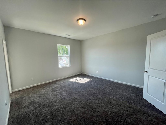 unfurnished room featuring dark carpet