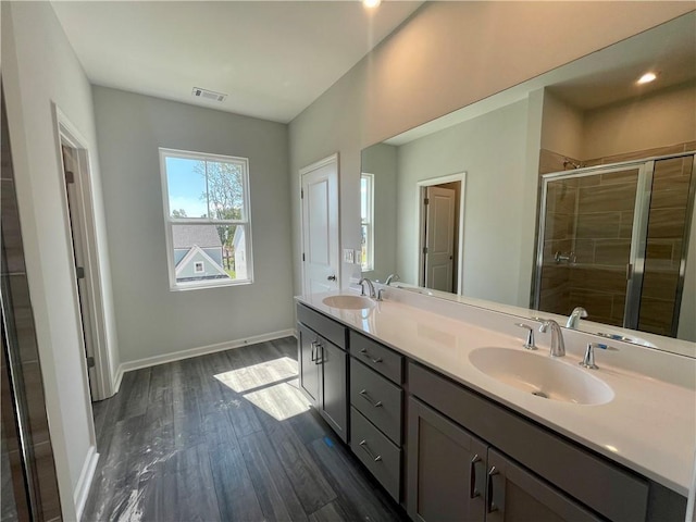 bathroom with hardwood / wood-style flooring, vanity, and an enclosed shower