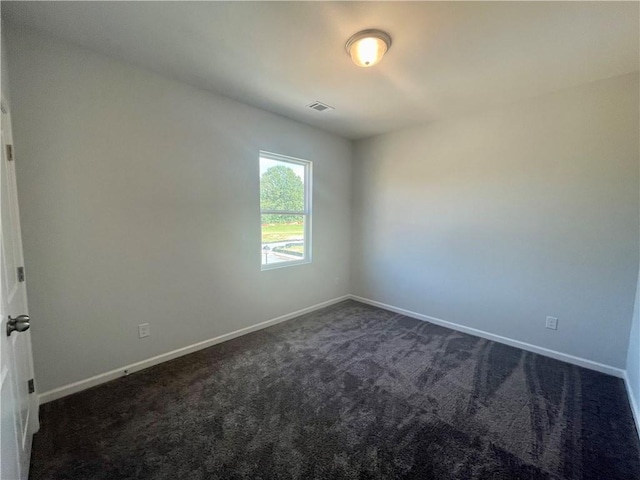 spare room with dark colored carpet