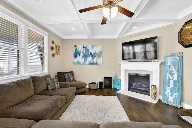 living area featuring dark wood-style floors, a glass covered fireplace, beam ceiling, and coffered ceiling